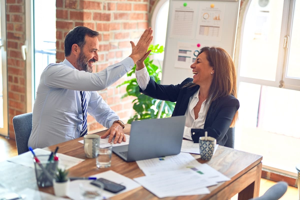 Two business professionals celebrating a successful consulting outcome