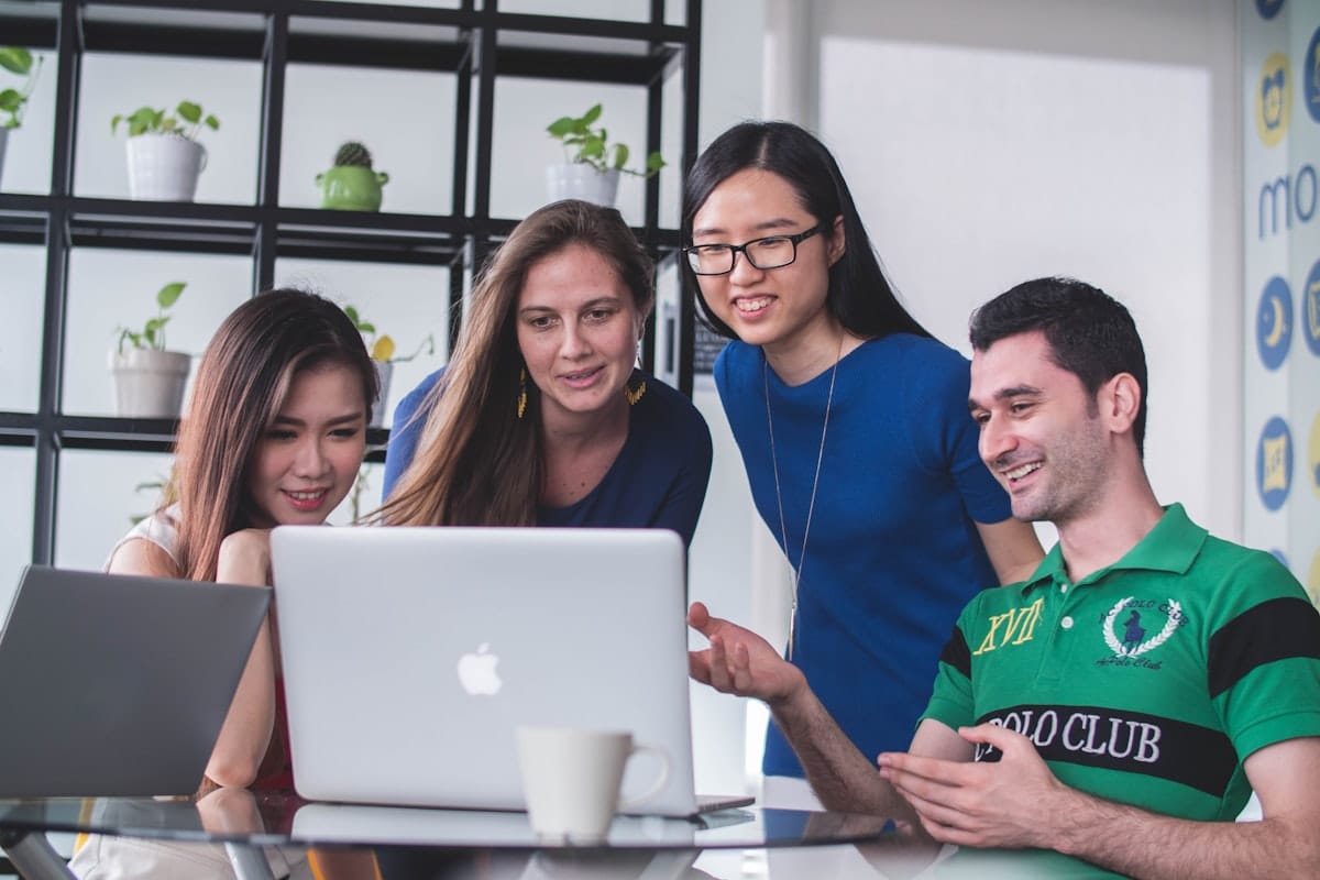 Diverse team collaborating on a project together around a laptop