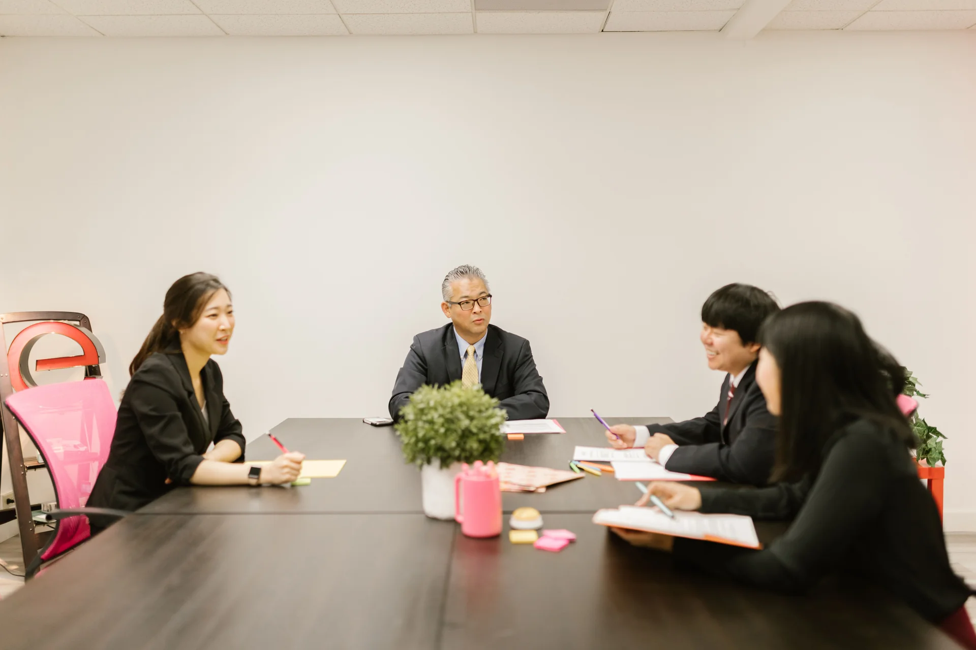 A group of people in a board meeting around a table