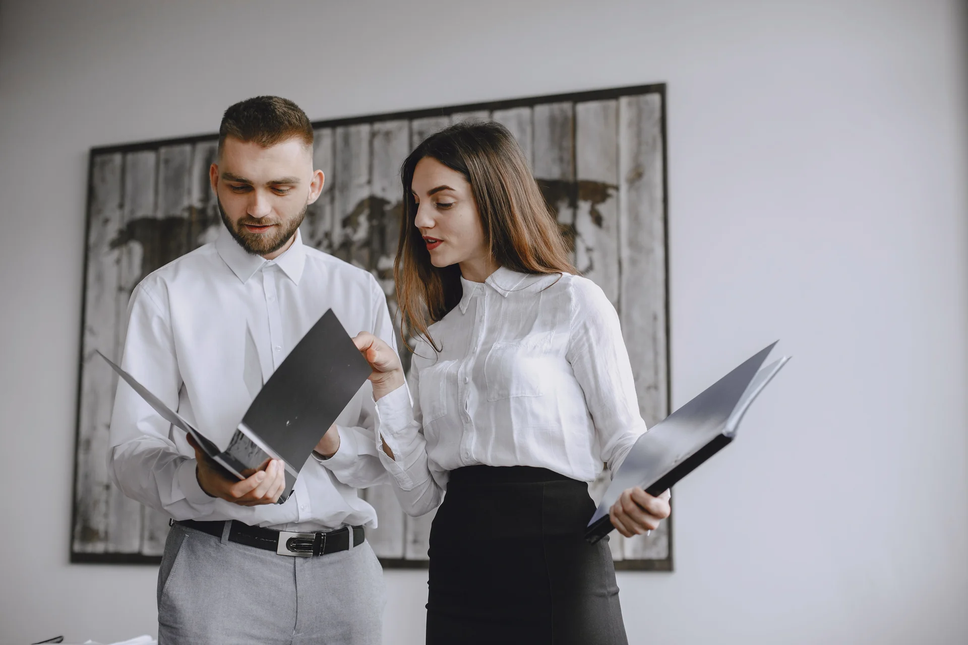 Colleagues going through printed documents at an office table