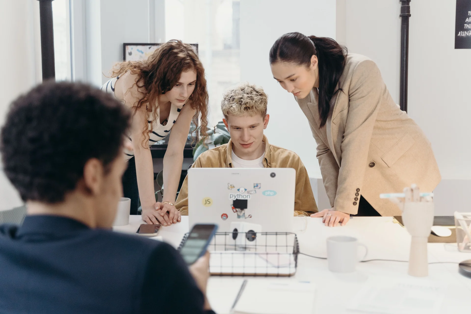 A small team looking at a laptop together at a meeting table