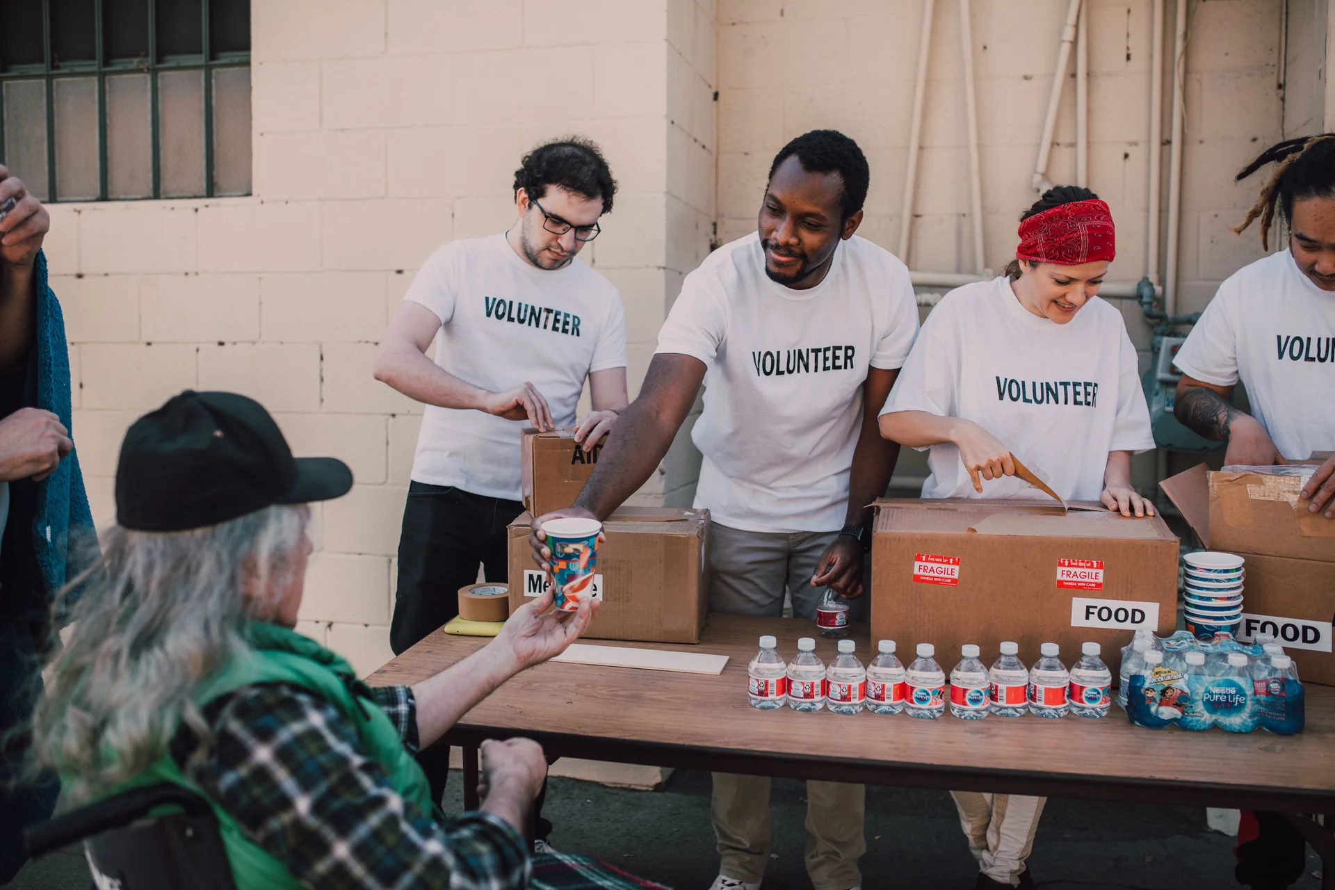 Volunteers handing over donated goods at a community centre