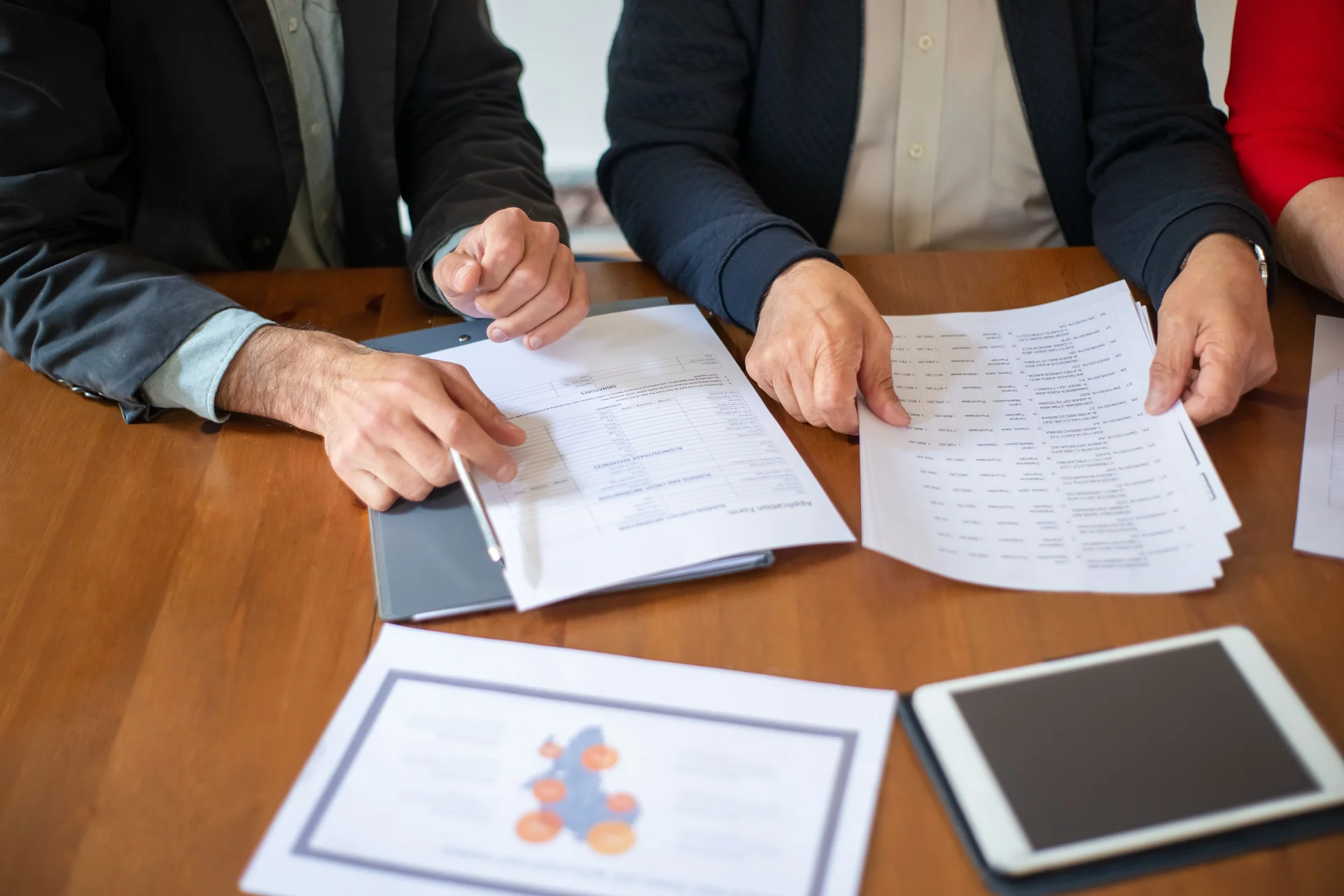 Colleagues reviewing printed documents together at a meeting table