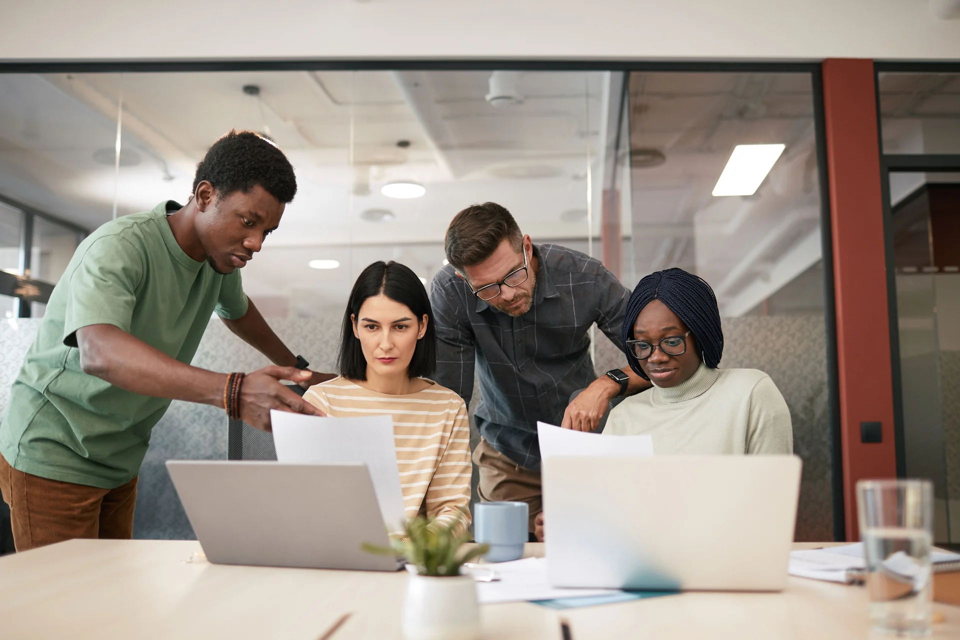 A team gathered around two laptops in an office