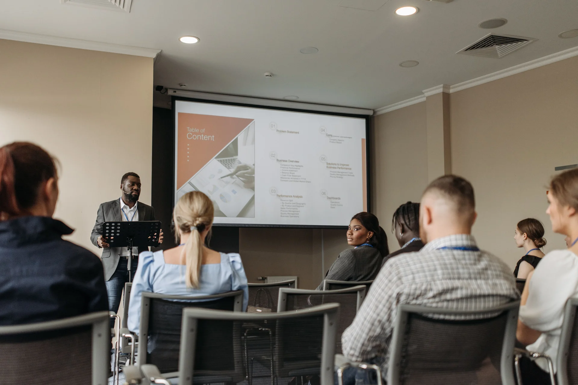 A group of people listening to a speaker at a meeting